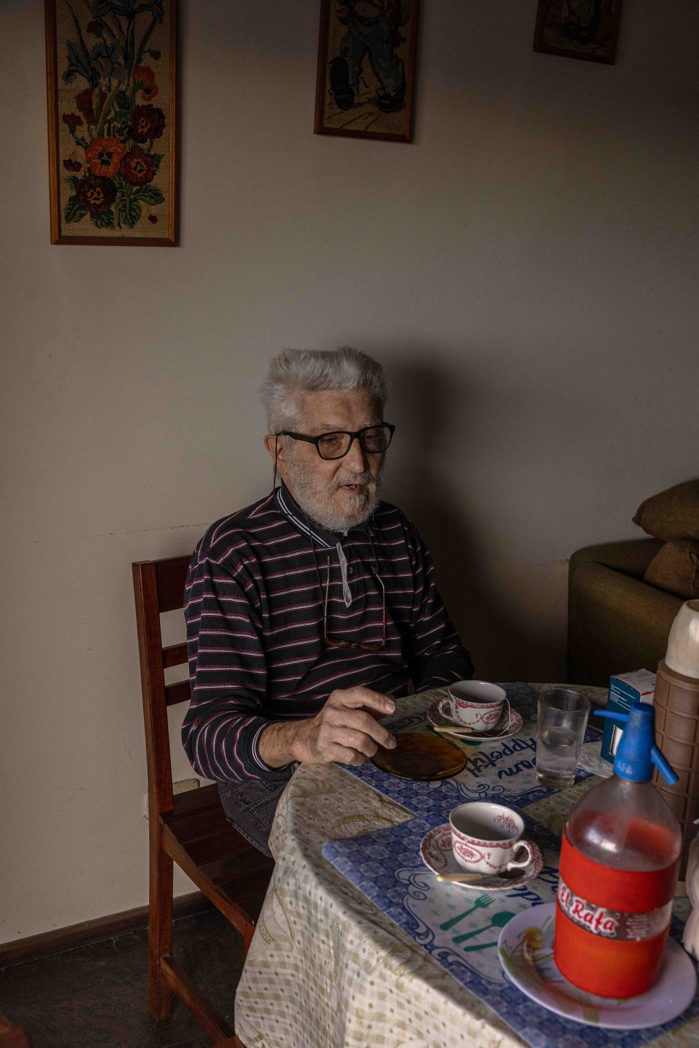 Una persona mayor sentada a la mesa en su casa